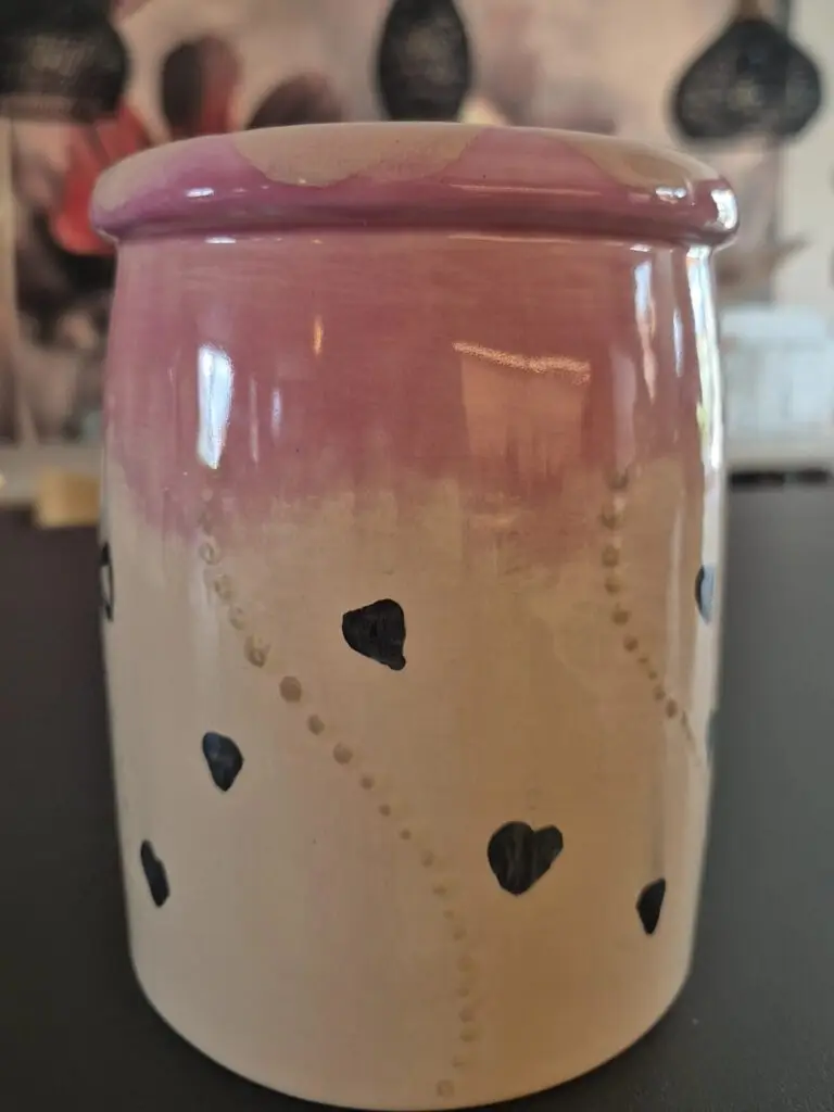 Pot met roze glazuur en een patroon van hartjes en stippen