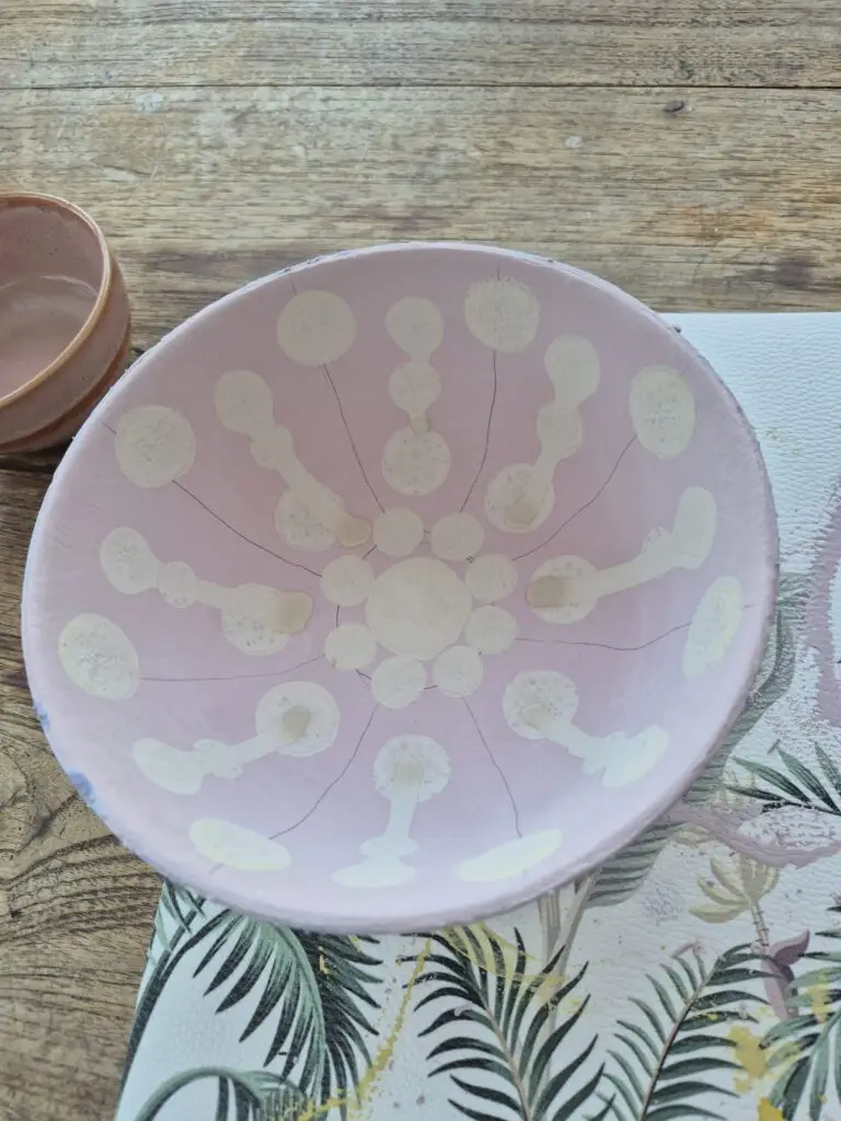 Roze schaal met wit stippenpatroon in stralen